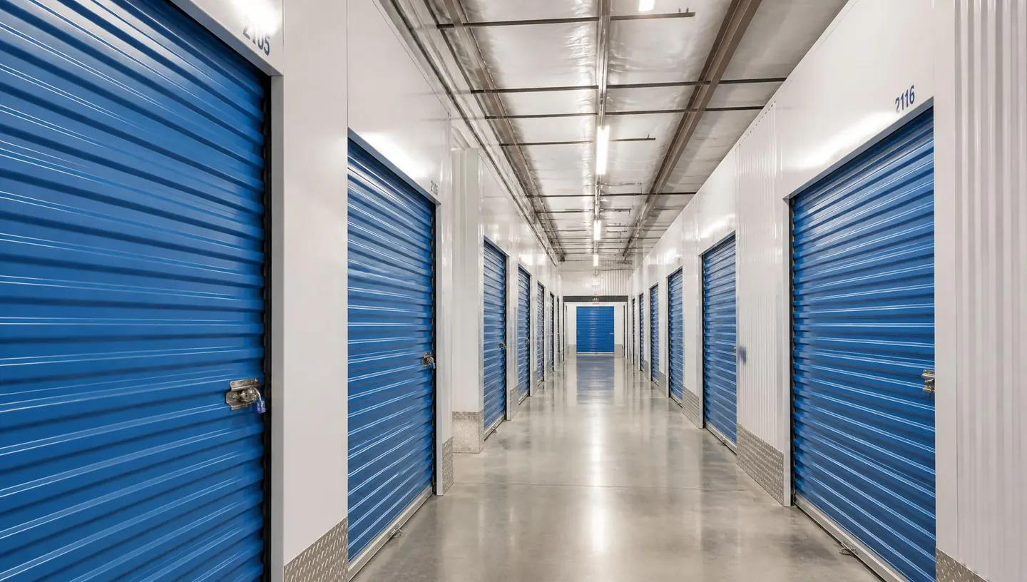 Bright corridor of blue storage unit doors inside a modern self storage facility